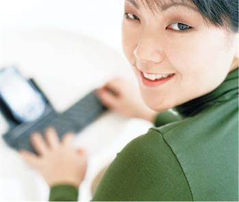 Woman typing on a keyboard at a desk.