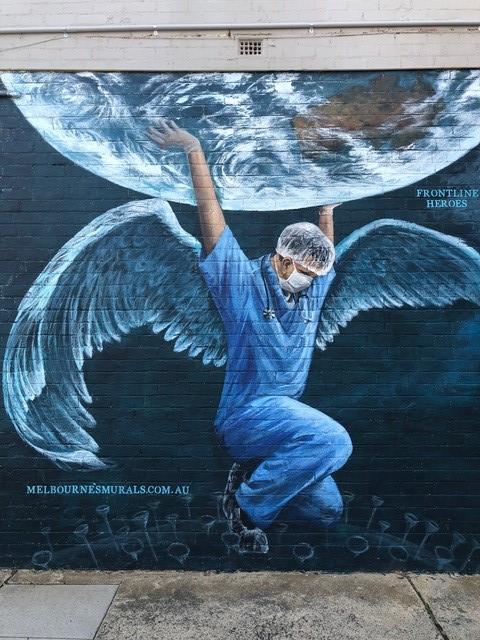 Health worker holding the world street art