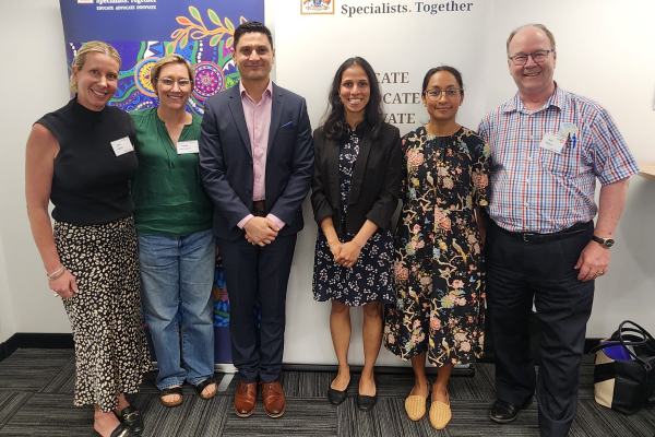 A group of six people standing indoors in front of two banners at the Adult Medicine Trainees Research Awards in Western Australia, 2025.