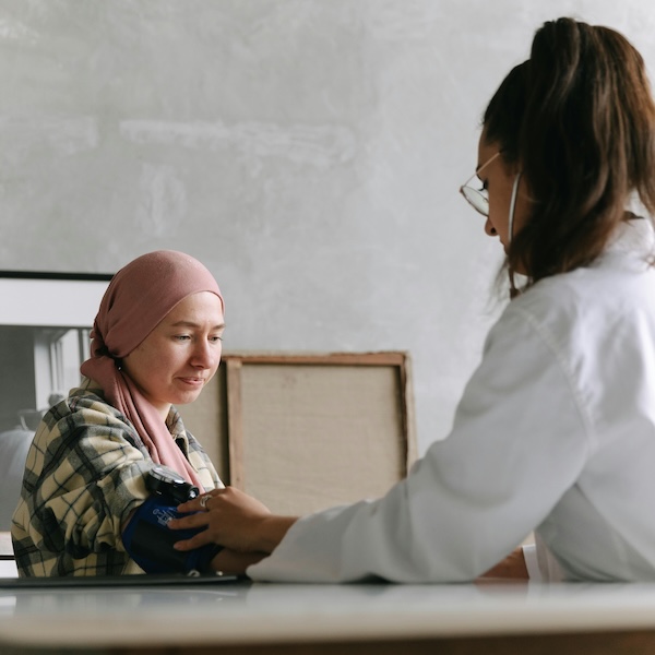 female doctor taking a patients blood pressure