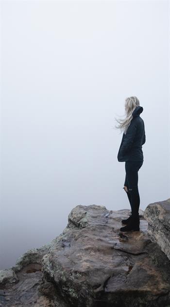 Pensive woman looking out over a cliff